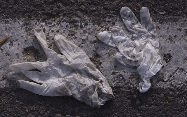 In this April 7, 2020, photo, a pair of gloves are thrown on the ground outside a supermarket during a lockdown following government measures to help stop the spread of the coronavirus in Tel Aviv, Israel. (AP Photo/Oded Balilty)