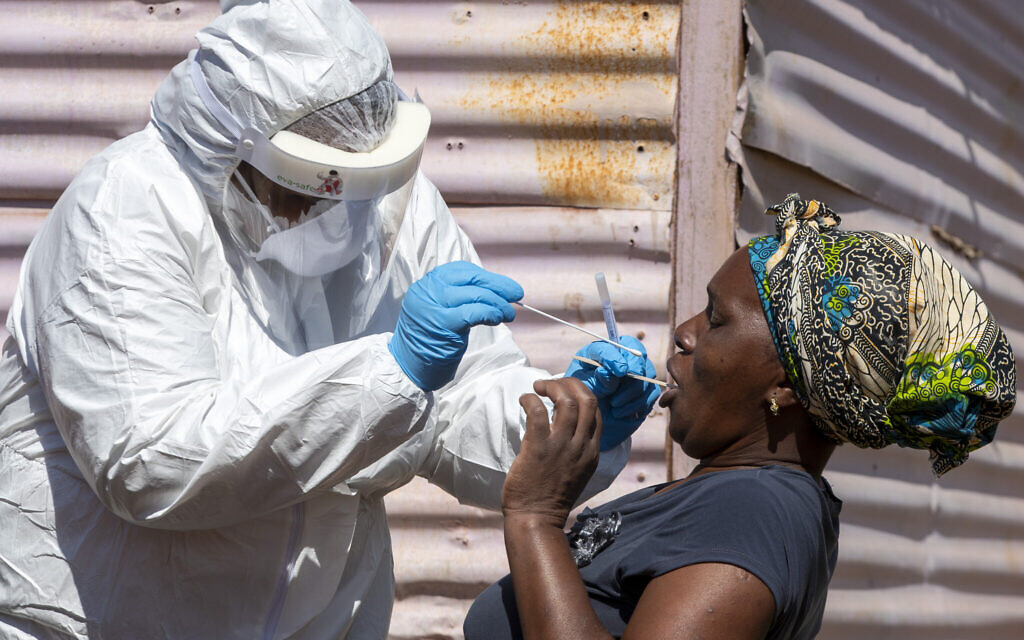 A woman opens her mouth for a heath worker to collect a sample for coronavirus testing at Lenasia South, south Johannesburg, South Africa, April 21, 2020. (AP Photo/Themba Hadebe)
