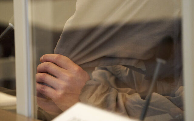 One of the defendants, Eyad A., is sitting on the bench of the Higher Regional Court behind Corona protective screens, hiding his face under a hood in Koblenz, Germany, on April 23, 2020. (Thomas Frey/dpa via AP) One of the defendants, Eyad A., is sitting on the bench of the Higher Regional Court behind Corona protective screens, hiding his face under a hood in Koblenz, Germany, on April 23, 2020. (Thomas Frey/dpa via AP)