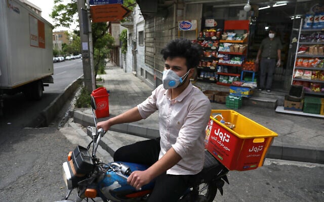 In this April 21, 2020 photo, grocery delivery man Saeed Vatanparast, wearing a protective face mask to help prevent the spread of the coronavirus, leaves on his motorcycle for a delivery, in Tehran, Iran. (AP Photo/Vahid Salemi) In this April 21, 2020 photo, grocery delivery man Saeed Vatanparast, wearing a protective face mask to help prevent the spread of the coronavirus, leaves on his motorcycle for a delivery, in Tehran, Iran. (AP Photo/Vahid Salemi)
