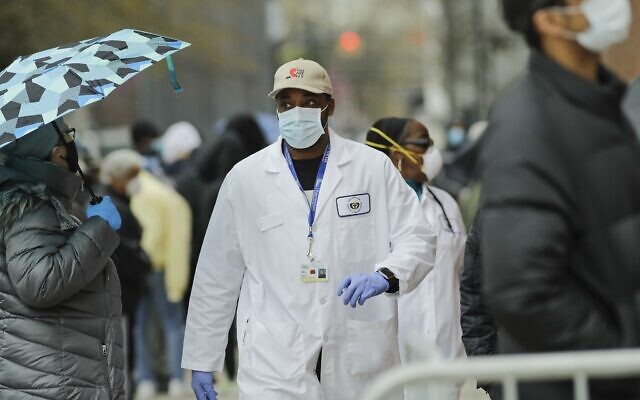 A US medical worker walks past people lined up at Gotham Health East New York, a COVID-19 testing center, on April 23, 2020, in the Brooklyn borough of New York. (AP Photo/Frank Franklin II) A US medical worker walks past people lined up at Gotham Health East New York, a COVID-19 testing center, on April 23, 2020, in the Brooklyn borough of New York. (AP Photo/Frank Franklin II)