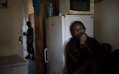 A woman sits inside her room in downtown Johannesburg, South Africa, on April 14, 2020. (AP Photo/Bram Janssen)
