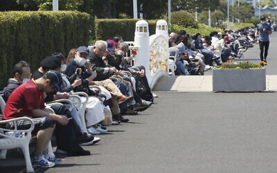 People sit on the bench at a park in Yokohama, near Tokyo, on a national holiday, April 29, 2020. (AP Photo/Koji Sasahara)