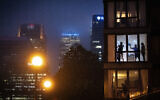 People play a makeshift ball game inside an apartment backdropped by London city buildings, as the UK continues in lockdown to help curb the spread of the coronavirus, April 28, 2020. (Victoria Jones / PA via AP)
