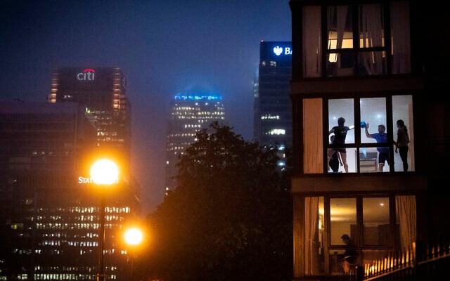 People play a makeshift ball game inside an apartment backdropped by London city buildings, as the UK continues in lockdown to help curb the spread of the coronavirus, April 28, 2020. (Victoria Jones / PA via AP) People play a makeshift ball game inside an apartment backdropped by London city buildings, as the UK continues in lockdown to help curb the spread of the coronavirus, April 28, 2020. (Victoria Jones / PA via AP)