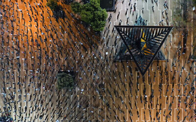 In this Saturday, April 25, 2020 photo, people keep social distancing amid concerns over the country's coronavirus outbreak, during "Black Flag" protest against Prime Minister Benjamin Netanyahu and government corruption, at Rabin Square in Tel Aviv, Israel. (AP Photo/Oded Balilty)