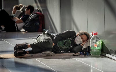 A passenger sleeps at Ezeiza International Airport in Buenos Aires, Argentina, on Monday, March 23, 2020. Many Argentines who returned from overseas struggle to get to their local destination amid travel restrictions put in place to help stop the spread of the new coronavirus. (AP Photo/Victor R. Caivano)