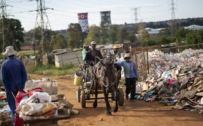 Men who collect trash to recycle bring it to a sales point in an informal settlement of Soweto, South Africa, March 25, 2020. (AP Photo/Jerome Delay)