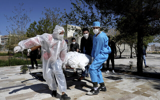 People wearing protective clothing carry the body of a victim who died after being infected with the new coronavirus at a cemetery just outside Tehran, Iran, Monday, March 30, 2020. (AP Photo/Ebrahim Noroozi) People wearing protective clothing carry the body of a victim who died after being infected with the new coronavirus at a cemetery just outside Tehran, Iran, Monday, March 30, 2020. (AP Photo/Ebrahim Noroozi)