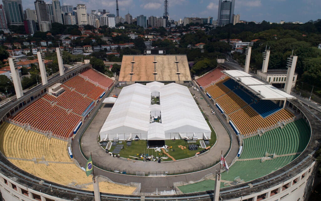 Workers set up a temporary field hospital to treat patients who have COVID-19 inside Pacaembu stadium in Sao Paulo, Brazil, Monday, March 30, 2020. (AP Photo/Andre Penner)