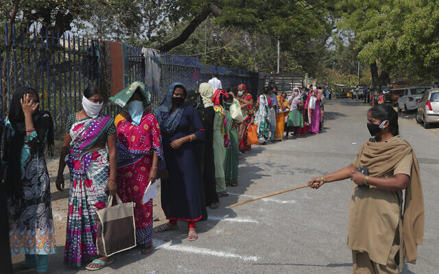 An Indian policewomen urges migrants to maintain social distance while standing in a queue to collect handouts given by the Telangana government during lockdown to prevent the spread of new coronavirus in Hyderabad, India, Tuesday, March 31, 2020. (AP Photo/Mahesh Kumar A.) An Indian policewomen urges migrants to maintain social distance while standing in a queue to collect handouts given by the Telangana government during lockdown to prevent the spread of new coronavirus in Hyderabad, India, Tuesday, March 31, 2020. (AP Photo/Mahesh Kumar A.)