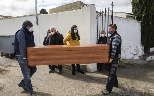 Undertakers carry the coffin of Rosalia Mascaraque, 86, during the coronavirus outbreak in Zarza de Tajo, central Spain, on April 1, 2020. . (AP Photo/Bernat Armangue) Undertakers carry the coffin of Rosalia Mascaraque, 86, during the coronavirus outbreak in Zarza de Tajo, central Spain, on April 1, 2020. . (AP Photo/Bernat Armangue)