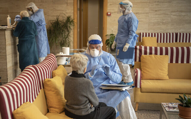 Illustrative: An aid worker talks to an elderly woman before a test at a nursing home in Barcelona, Spain, April 1, 2020. (AP Photo/Santi Palacios) Illustrative: An aid worker talks to an elderly woman before a test at a nursing home in Barcelona, Spain, April 1, 2020. (AP Photo/Santi Palacios)