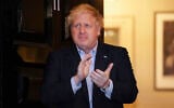 Britain's Prime Minister Boris Johnson claps outside 11 Downing Street to salute local heroes during a nationwide initiative to applaud workers fighting the coronavirus pandemic, in London, April 2, 2020. (Pippa Fowles/10 Downing Street via AP)