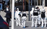 Police officers investigate after a man wielding a knife attacked residents venturing out to shop in the town under lockdown, Saturday April 4, 2020 in Romans-sur-Isere, southern France. (AP)
