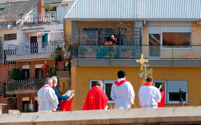 A faithful from a facing balcony follows the celebration of the Palm Sunday mass on the roof of the church of San Pio X, in Rome, Sunday, April 5, 2020. Churches are closed to faithful all over Italy due to the coronavirus outbreak. (Mauro Scrobogna/LaPresse via AP) A faithful from a facing balcony follows the celebration of the Palm Sunday mass on the roof of the church of San Pio X, in Rome, Sunday, April 5, 2020. Churches are closed to faithful all over Italy due to the coronavirus outbreak. (Mauro Scrobogna/LaPresse via AP)