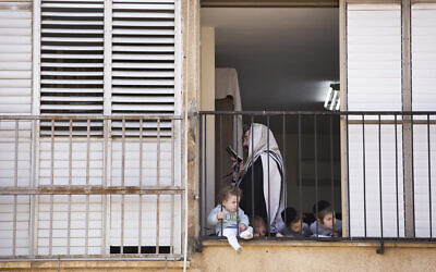 Illustrative: An Ultra-Orthodox Jew prays a morning prayer at his house, during a lockdown following the government's measures to help stop the spread of the coronavirus, in Bnei Brak, Israel, Wednesday, April 8, 2020. (AP Photo/Oded Balilty)