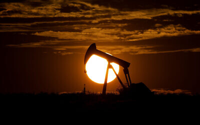 The sun sets behind an idle pump jack near Karnes City, Texas, April 8, 2020 (AP Photo/Eric Gay)