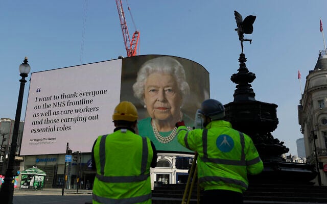An image of Britain's Queen Elizabeth II and quotes from her historic television broadcast commenting on the coronavirus pandemic are displayed on a big screen behind the Eros statue at Piccadilly Circus in London, April 9, 2020. (AP Photo/Kirsty Wigglesworth)