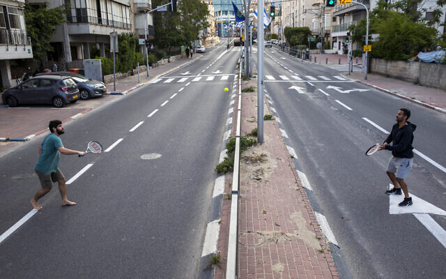 File: Israelis play tennis on an empty road during lockdown following the government's measures to help stop the spread of the coronavirus, in Ramat Gan, near Tel Aviv, April 9, 2020. (AP Photo/Oded Balilty) File: Israelis play tennis on an empty road during lockdown following the government's measures to help stop the spread of the coronavirus, in Ramat Gan, near Tel Aviv, April 9, 2020. (AP Photo/Oded Balilty)