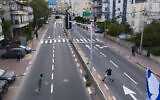 Israelis play tennis on an empty road during lockdown, following the government's measures to help stop the spread of the coronavirus, in Ramat Gan, near Tel Aviv, Israel, April 9, 2020. (AP/ Oded Balilty)