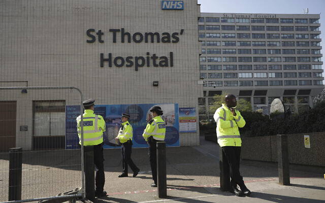 Three police officers at left and a security guard at right guard an entrance outside St Thomas' Hospital in London, where British Prime Minister Boris Johnson is being treated for coronavirus on April 10, 2020. (AP/Matt Dunham) Three police officers at left and a security guard at right guard an entrance outside St Thomas' Hospital in London, where British Prime Minister Boris Johnson is being treated for coronavirus on April 10, 2020. (AP/Matt Dunham)