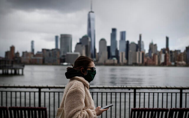 The downtown New York City skyline looms over pedestrians wearing masks due to COVID-19 concerns, Friday, April 10, 2020, in Jersey City, NJ (AP Photo/John Minchillo) The downtown New York City skyline looms over pedestrians wearing masks due to COVID-19 concerns, Friday, April 10, 2020, in Jersey City, NJ (AP Photo/John Minchillo)