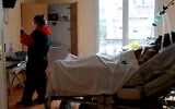 A medic takes care of a patient affected by COVID-19 virus in the ICU unit at the Ambroise Pare clinic in Neuilly-sur-Seine, near Paris, April 10, 2020 (AP Photo/Christophe Ena)