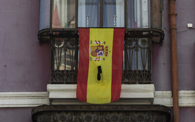 A Spanish flag on a window ledge with a black ribbon in Madrid,  April 12, 2020. (AP Photo/Bernat Armangue)