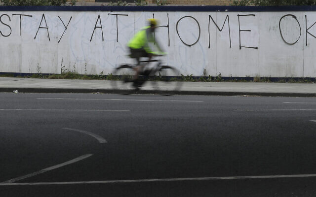 A cyclist passes graffiti in London on Monday, April 13, 2020. (AP/Kirsty Wigglesworth)