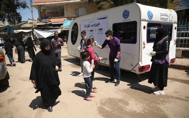 A member of a non-governmental aid organization measures temperature as a preventive measure for coronavirus in the town of Kafr Takharim, Idlib province, Syria, April 14, 2020. (AP Photo/Ghaith Alsayed) A member of a non-governmental aid organization measures temperature as a preventive measure for coronavirus in the town of Kafr Takharim, Idlib province, Syria, April 14, 2020. (AP Photo/Ghaith Alsayed)
