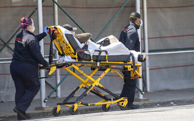 Medics transport a patient to the King David Center for Nursing and Rehabilitation in the Gravesend neighborhood of the Brooklyn borough of New York, Wednesday, April 15, 2020.  (AP Photo/Mary Altaffer)