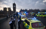 London Ambulance staff, police officers and firefighters take part in the weekly "clap for our carers" as they stand on Westminster Bridge backdropped by a scaffolded Big Ben and the Houses of Parliament in London, during the lockdown to try and stop the spread of the coronavirus,  April 16, 2020. (AP Photo/Matt Dunham)