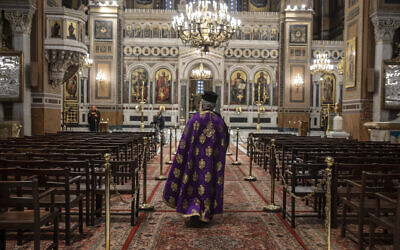 In this April 13, 2020, photo a priest takes part in a Holy Monday ceremony held without worshipers at the Athens Cathedral, in Greece, during a lockdown order by the government to prevent the spread of the coronavirus (AP Photo/Petros Giannakouris)