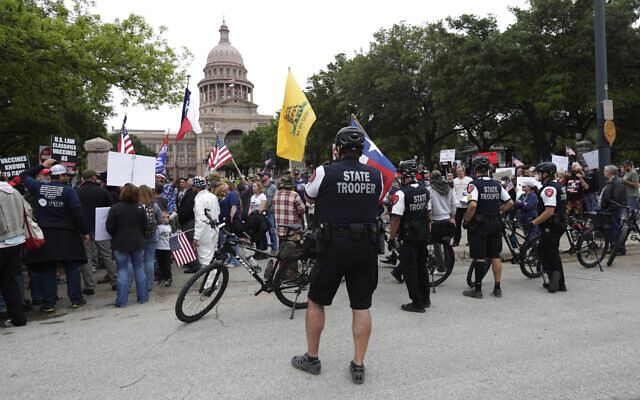 State troopers keep watch as protesters rally at the Texas State Capitol to speak out against Texas' handling of the COVID-19 outbreak, in Austin, Texas, Saturday, April 18, 2020. (AP/Eric Gay) State troopers keep watch as protesters rally at the Texas State Capitol to speak out against Texas' handling of the COVID-19 outbreak, in Austin, Texas, Saturday, April 18, 2020. (AP/Eric Gay)