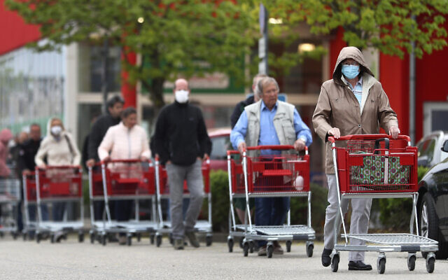 People wearing protective masks line up to go in a garden store in Munich, Germany, April 20, 2020. (AP Photo/Matthias Schrader) People wearing protective masks line up to go in a garden store in Munich, Germany, April 20, 2020. (AP Photo/Matthias Schrader)