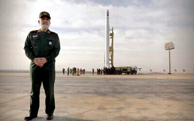 In this photo released April 22, 2020, by Sepahnews, Gen. Amir Ali Hajizadeh, the head of the Revolutionary Guard's aerospace division, stands in front of an Iranian rocket carrying a satellite in an undisclosed site believed to be in Iran's Semnan province. (Sepahnews via AP)