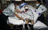 FILE - In this Monday, April 20, 2020, file photo, emergency medical technicians transport a patient from a nursing home to an emergency room bed at St. Joseph's Hospital in Yonkers, New York (AP/John Minchillo, File)