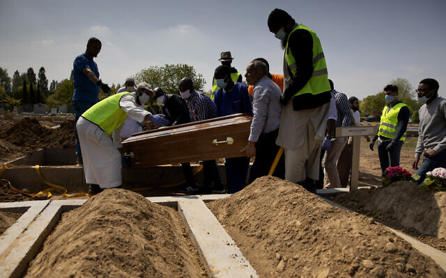 Mourners set down the coffin of a Guinean man who died of COVID-19 during a funeral at the cemetery of Evere, Belgium, Friday, April 24, 2020 (AP Photo/Virginia Mayo) Mourners set down the coffin of a Guinean man who died of COVID-19 during a funeral at the cemetery of Evere, Belgium, Friday, April 24, 2020 (AP Photo/Virginia Mayo)