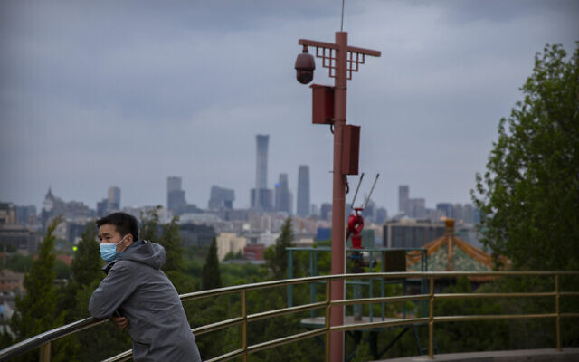 A man wearing a face mask to protect against the spread of the new coronavirus stands on a hilltop at a public park in Beijing, Saturday, April 25, 2020. (AP/Mark Schiefelbein) A man wearing a face mask to protect against the spread of the new coronavirus stands on a hilltop at a public park in Beijing, Saturday, April 25, 2020. (AP/Mark Schiefelbein)