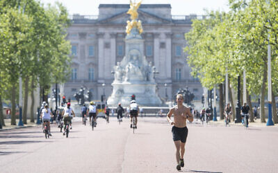 A runner on the Mall in central London, where the finish of the London Marathon course would be, which was postponed to help curb the spread of the coronavirus, Sunday April 26, 2020. (Dominic Lipinski/PA via AP)