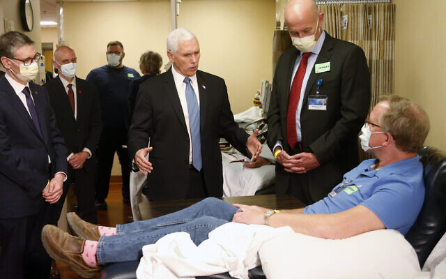 US Vice President Mike Pence, center, visits Dennis Nelson, a patient who survived the coronavirus and was going to give blood, during a tour of the Mayo Clinic Tuesday, April 28, 2020, in Rochester, Minn., as he toured the facilities supporting COVID-19 research and treatment. Pence chose not to wear a face mask while touring the Mayo Clinic in Minnesota. It's an apparent violation of the world-renowned medical center's policy requiring them. (AP Photo/Jim Mone) US Vice President Mike Pence, center, visits Dennis Nelson, a patient who survived the coronavirus and was going to give blood, during a tour of the Mayo Clinic Tuesday, April 28, 2020, in Rochester, Minn., as he toured the facilities supporting COVID-19 research and treatment. Pence chose not to wear a face mask while touring the Mayo Clinic in Minnesota. It's an apparent violation of the world-renowned medical center's policy requiring them. (AP Photo/Jim Mone)