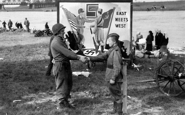 A soldier with the 1st US Army shakes hands with a Soviet counterpart, emulating the 'East Meets West' sign in the background, during the historic meeting of Allied fronts, by the river Elbe at Torgau, Germany, April 26, 1945. (AP/William C. Allen) A soldier with the 1st US Army shakes hands with a Soviet counterpart, emulating the 'East Meets West' sign in the background, during the historic meeting of Allied fronts, by the river Elbe at Torgau, Germany, April 26, 1945. (AP/William C. Allen)