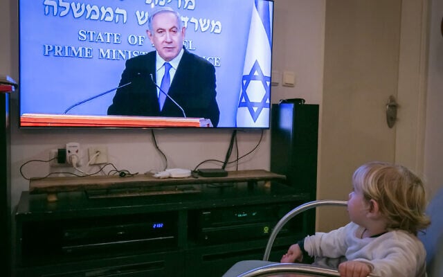 An Israeli child watch as Israeli prime minister Benjamin Netanyahu holds a live press conference on the new government restrictions for the public regarding the coronavirus COVID-19 on March 19, 2020. (Chen Leopold/Flash90) An Israeli child watch as Israeli prime minister Benjamin Netanyahu holds a live press conference on the new government restrictions for the public regarding the coronavirus COVID-19 on March 19, 2020. (Chen Leopold/Flash90)