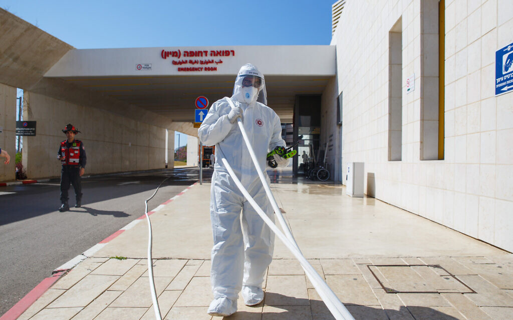 Firefighters wearing protective clothes disinfect Assuta hospital in Ashdod, on March 22, 2020 (Flash90) Firefighters wearing protective clothes disinfect Assuta hospital in Ashdod, on March 22, 2020 (Flash90)