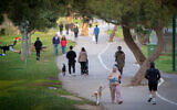Israelis walk their dogs and exercise in  Tel Aviv's Yarkon Park on March 22, 2020, as the government issued instructions to avoid public spaces to prevent the spread of the coronavirus (Miriam Alster/Flash90)
