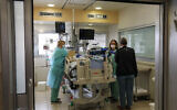 Staff move a patient to a new ward at the Ichilov Hospital in Tel Aviv, March 22, 2020. (Yossi Zamir/Flash90)
