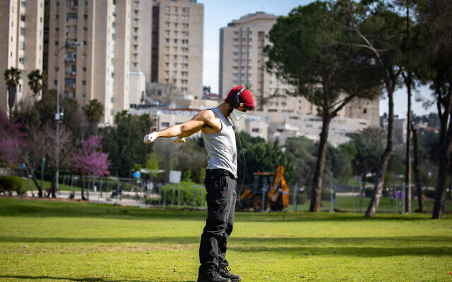 A man wearing a face mask exercises in the Saker Park in Jerusalem, on March 25, 2020. (Olivier Fitoussi/Flash90) A man wearing a face mask exercises in the Saker Park in Jerusalem, on March 25, 2020. (Olivier Fitoussi/Flash90)