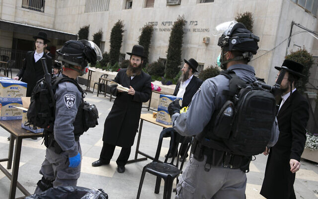 Illustrative: Police officers at a synagogue in the ultra-Orthodox neighborhood of Mea Shearim in Jerusalem as they close shops and disperse public gatherings for violating emergency directives against the coronavirus, March 30, 2020. (Olivier Fitoussi/Flash90) Illustrative: Police officers at a synagogue in the ultra-Orthodox neighborhood of Mea Shearim in Jerusalem as they close shops and disperse public gatherings for violating emergency directives against the coronavirus, March 30, 2020. (Olivier Fitoussi/Flash90)