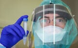 A lab technician carries out a coronavirus test at Rambam Medical Center in Haifa on March 30, 2020. (Yossi Aloni/Flash90)